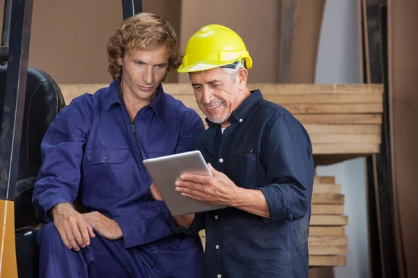 Carpinteiro usando tablet digital com colegas — Fotografia de Stock