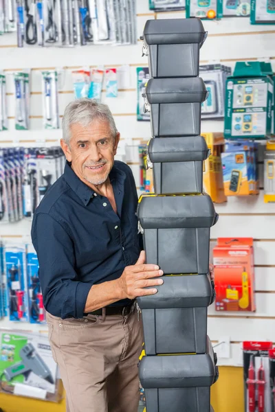 Selbstbewusster Senior stapelt Werkzeugkisten im Geschäft — Stockfoto