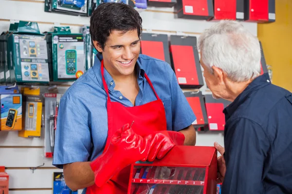 Verkäufer zeigt Mann im Geschäft Bohrmaschine — Stockfoto