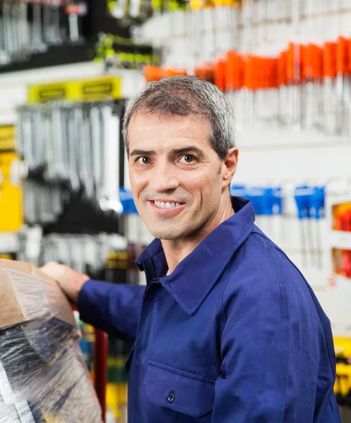 Уверенный в себе зрелый рабочий улыбается в магазине оборудования — стоковое фото