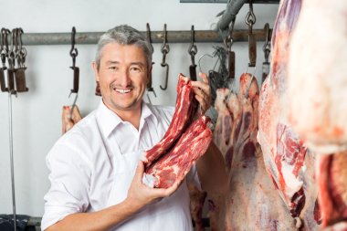 Butcher Holding Fresh Meat In Slaughterhouse clipart