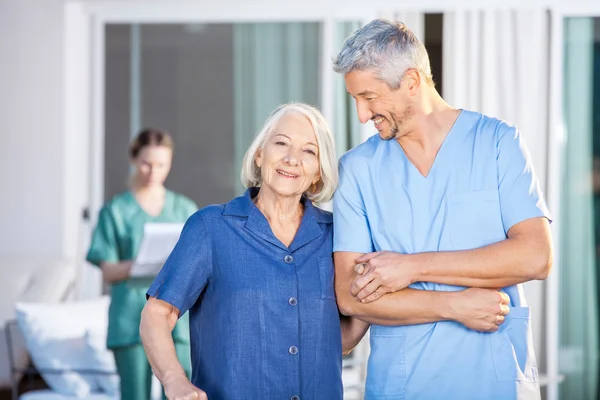 Happy Senior Woman Standing With Male Caretaker — Stock Photo, Image