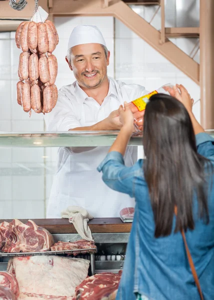 Homem dando salsichas embaladas para cliente feminino — Fotografia de Stock