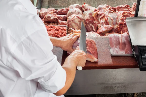 Imagem cortada da carne de corte do açougueiro masculino — Fotografia de Stock