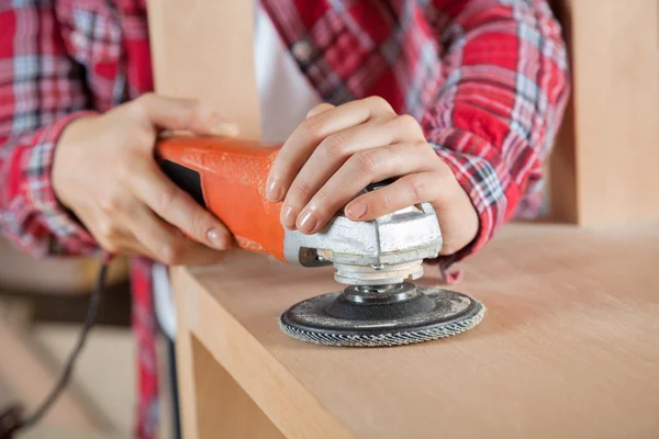 Carpinteiros mãos usando lixadeira na prateleira de madeira — Fotografia de Stock