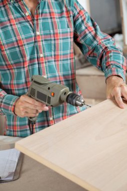 Marangoz atölyesinde elektrikli matkap kullanarak