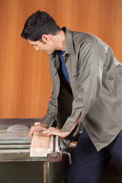 Tischler schneidet Holz mit der Tischsäge — Stockfoto