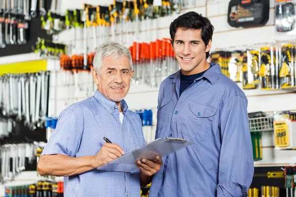 Vader en zoon voorbereiding controlelijst In Hardware Store — Stockfoto