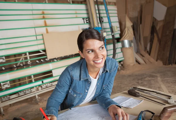 Carpentiere femminile riflessivo che lavora sul progetto — Foto Stock