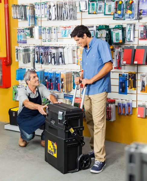 Vendedor mostrando la caja de herramientas al cliente en la tienda — Foto de Stock