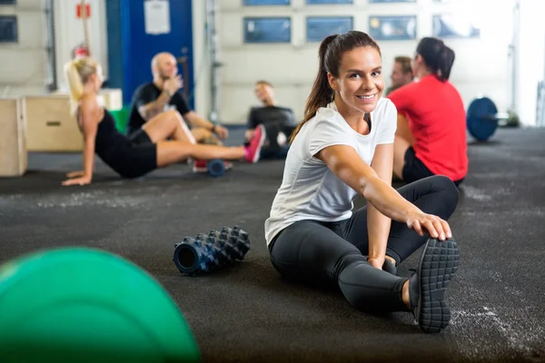 Kobieta robi, Stretching ćwiczenia na Krzyż szkolenia pole — Zdjęcie stockowe