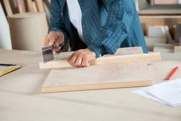 Tesař řezání dřeva s viděl v Workbench — Stock fotografie