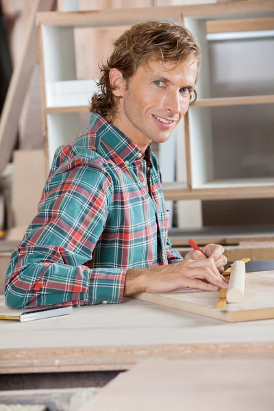 Confident Carpenter Measuring Wood At Table — Stock Photo, Image