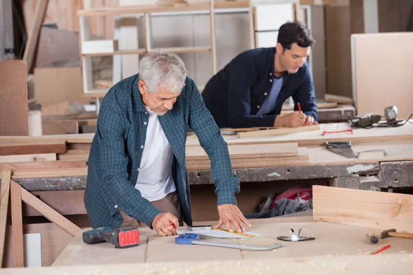 Senior-Schreiner zeichnet Diagramm auf Blaupause — Stockfoto