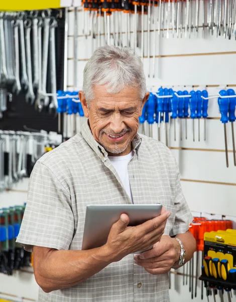 Senior Man met behulp van digitale Tablet In Hardware winkel — Stockfoto