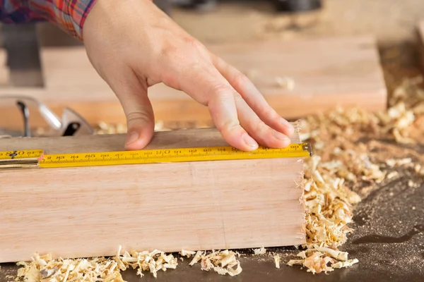 Carpinteiros mão medição de madeira com escala — Fotografia de Stock
