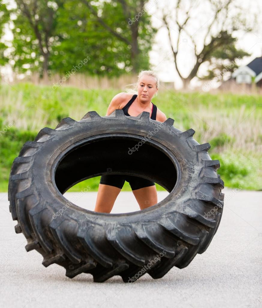 Fit Woman Flipping Tire Outdoors