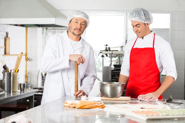 Chef de pie con sus colegas de preparación de pasta Ravioli en la cocina —  Fotos de Stock