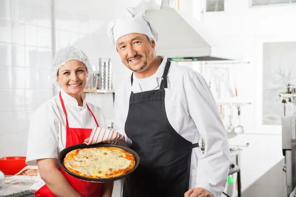 Confident Chefs With Pizza Pan At Commercial Kitchen — Stock Photo, Image