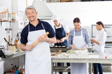 Kendine güvenen erkek Şef Holding oklava meslektaşları Prepari süre