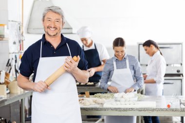 Mutlu Şef Holding oklava iken meslektaşları makarna hazırlama