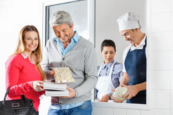 Couple tenant des paquets de pâtes par les chefs à la fenêtre — Photo