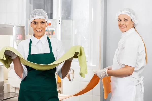 Chefs féminins heureux tenant des feuilles de pâtes à la cuisine — Photo