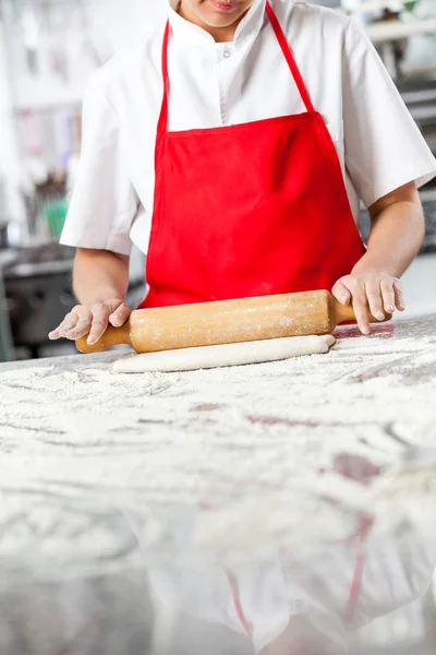 Chef balanceo masa en desordenado contador — Foto de Stock