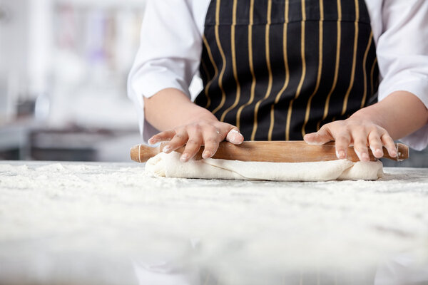 Female Chef Rolling Dough At Messy Counter