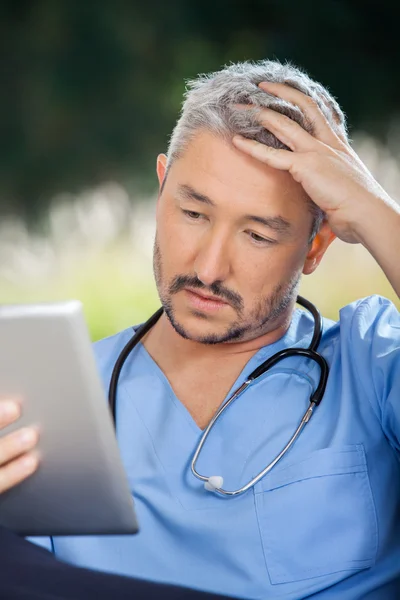 Tensed Male Caretaker Using Tablet PC — Stock Photo, Image