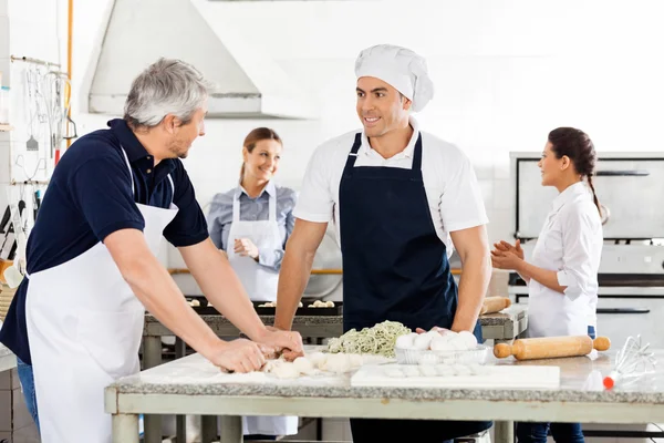 Chef-koks praten tijdens het voorbereiden van de Pasta op commerciële keuken — Stockfoto