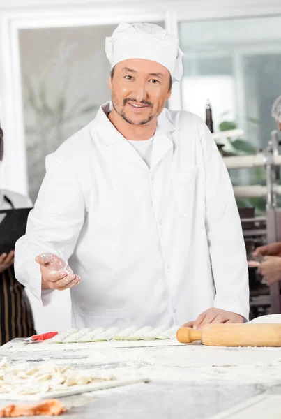 Chef sorridente Polvere Farina Su Ravioli Pasta In Cucina — Foto Stock