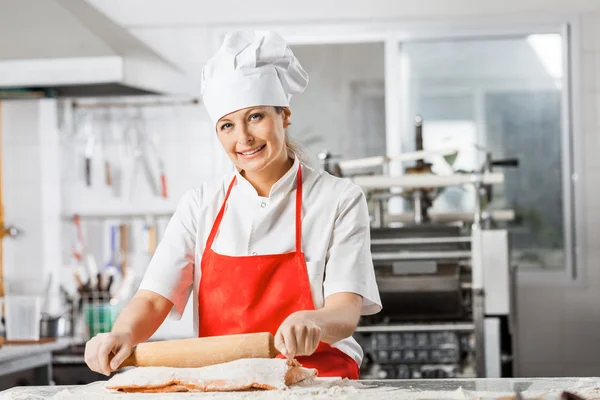 Chef feliz balanceo hoja de pasta en la cocina —  Fotos de Stock