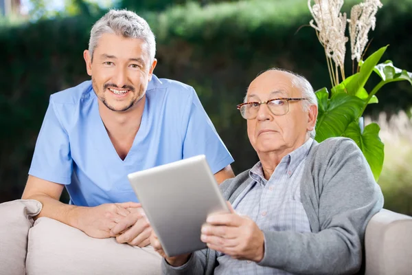 Gardien masculin et homme âgé tenant tablette numérique — Photo