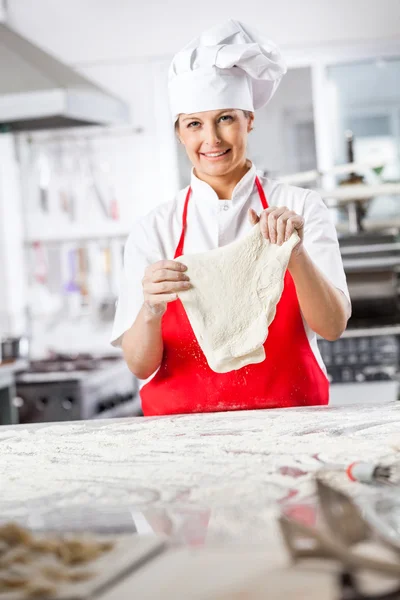 Beautiful Female Chef Holding Dough At Counter — Stock Photo, Image