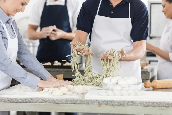 Bránice kuchaři připravují těstoviny v kuchyni — Stock fotografie