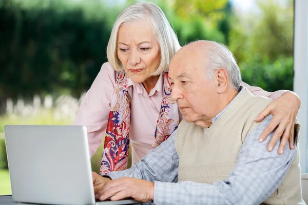 Sério homem sênior e mulher usando laptop — Fotografia de Stock