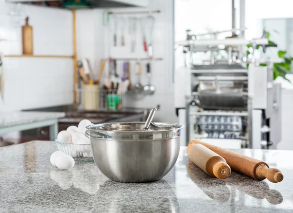 Tigela com ovos e rolo de pino na cozinha comercial — Fotografia de Stock