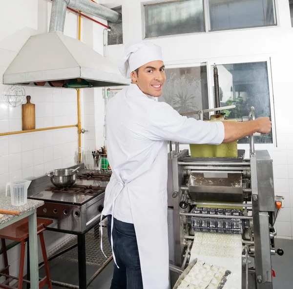 Hoja de pasta de procesamiento de chef sonriente en maquinaria —  Fotos de Stock