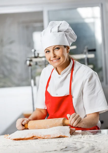 Glimlachen van chef-kok rollen Pasta blad aan balie — Stockfoto