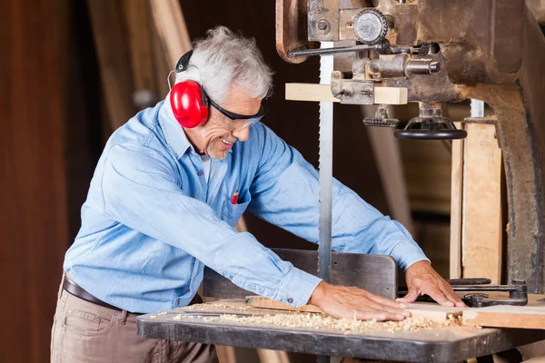 Carpenter Cutting Wood with Bandsaw — стоковое фото