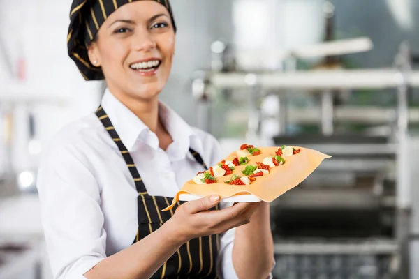 Vrolijke chef-kok bedrijf dienblad met gevulde Pasta blad — Stockfoto