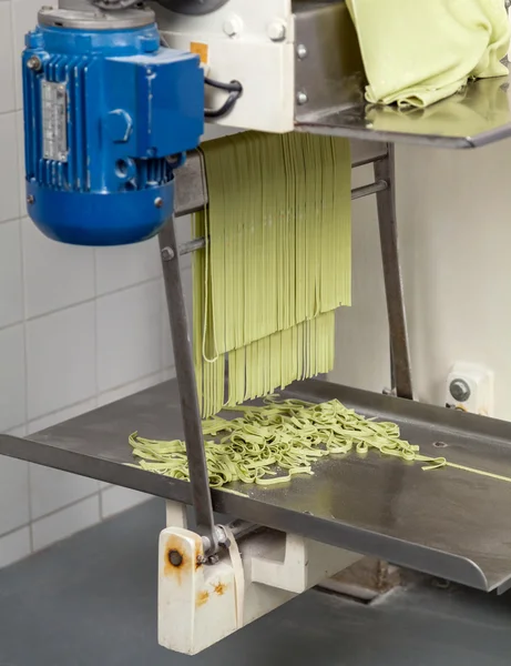 Pâtes spaghetti vertes en cours de traitement dans la machine — Photo