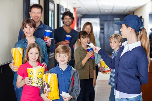 Worker Giving Tickets To Families At Cinema — Stock Photo, Image