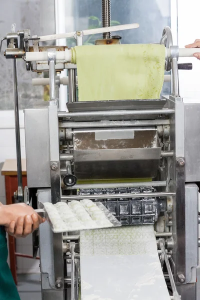 Chef femelle tenant le plateau de pâtes Ravioli par la machine — Photo