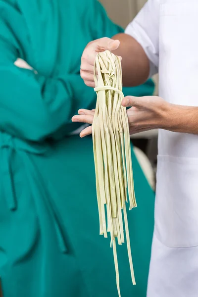 Makaron Spaghetti gospodarstwa szefa kuchni w kuchni — Zdjęcie stockowe