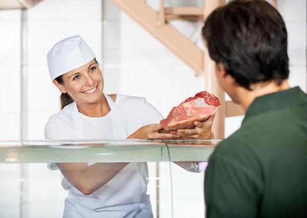 Slaktaren sälja färskt kött till kund — Stockfoto