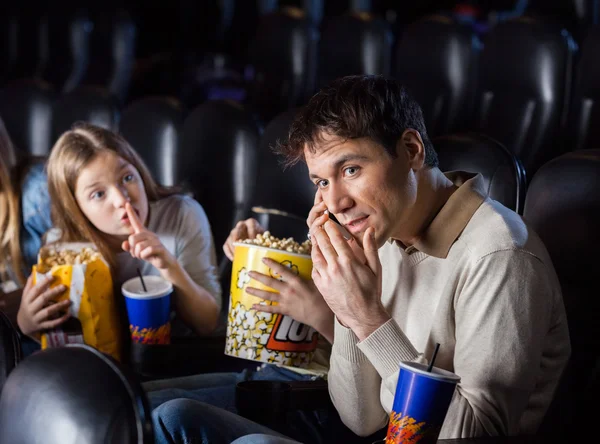 Enojada hija mirando a padre usando móvil en teatro —  Fotos de Stock