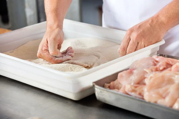 Carnicero añadiendo harina a la pieza de pollo — Foto de Stock