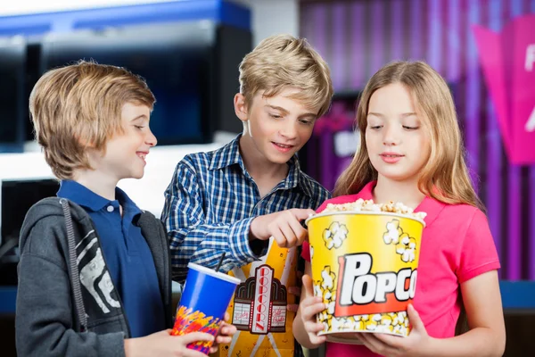 Fratello e sorella holding snack a cinema — Foto Stock